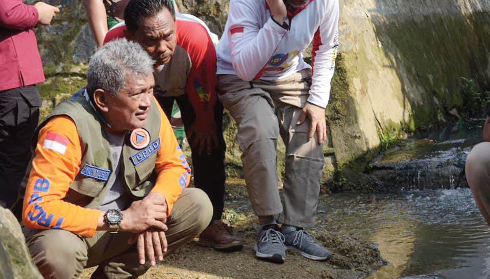 Pj Wali Kota Kendari, Muhammad Yusup turun langsung di lapangan mengecek kondisi saluran air yang tersumbat oleh material lumpur dan sampah.