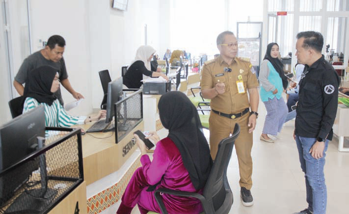 Kepala Disdukcapil Kota Kendari, Iswanto Dongge (pakaian dinas) bersama dengan Wadir Kendari Pos Awal Nurjadin memantau proses pelayanan admnistrasi kependudukan warga di kantor Disdukcapil Kota Kendari. (FOTO-FOTO: MUH. ABDI ASMAUL AMRIN/KENDARI POS)