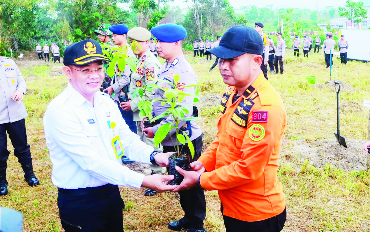 PENANAMAN POHON : Asisten III Setda Kota Kendari, Makmur menyerahkan bibit pohon kepada stakeholder terkait, kemarin. (AGUS SETIAWAN/ KENDARI POS)