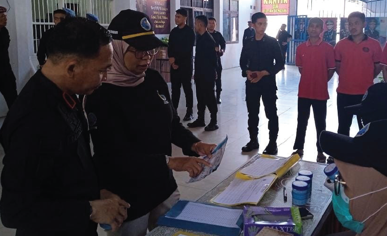 TES URINE : Kepala Rutan Kelas II A Kendari, Herianto (kiri) dan Kepala BNN Kota Kendari,Yuanita Amelia Sari (topi htam) mengecek peralatan tes urine di Rutan Kelas II A Kendari, Kamis (27/6). (RAHMA SAFITRI/KENDARI POS)