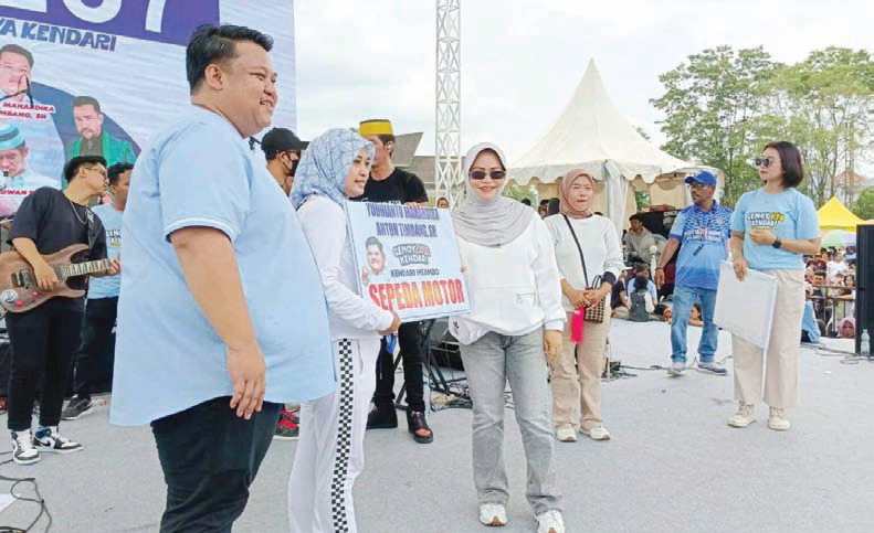 Calon Wali Kota Kendari, Yudhianto Mahardika Anton Timbang didampingi Hj Nirna Lachmuddin menyerahkan hadiah kepada pemenang undian jalan sehat, kemarin.