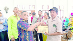 Pj Bupati Mubar, La Ode Butolo (kiri) didampingi Kalak BPBD Mubar, Karimin (baju hijau) menyerahkan bantuan uang tunai kepada korban bencana.(AKHIRMAN/KENDARI POS )