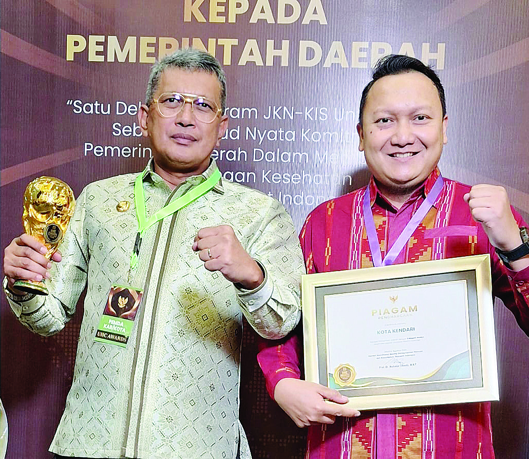 PENGHARGAAN: Pj Wali Kota Kendari, Muhammad Yusup (kiri) bersama Kepala Cabang BPJS Kendari, Rinaldi Wibisono (kanan) foto bersama usai menerima penghargaan UHC di Jakarta, Kamis (8/8/2024). (HUMAS PEMKOT KENDARI FOR KENDARI POS)