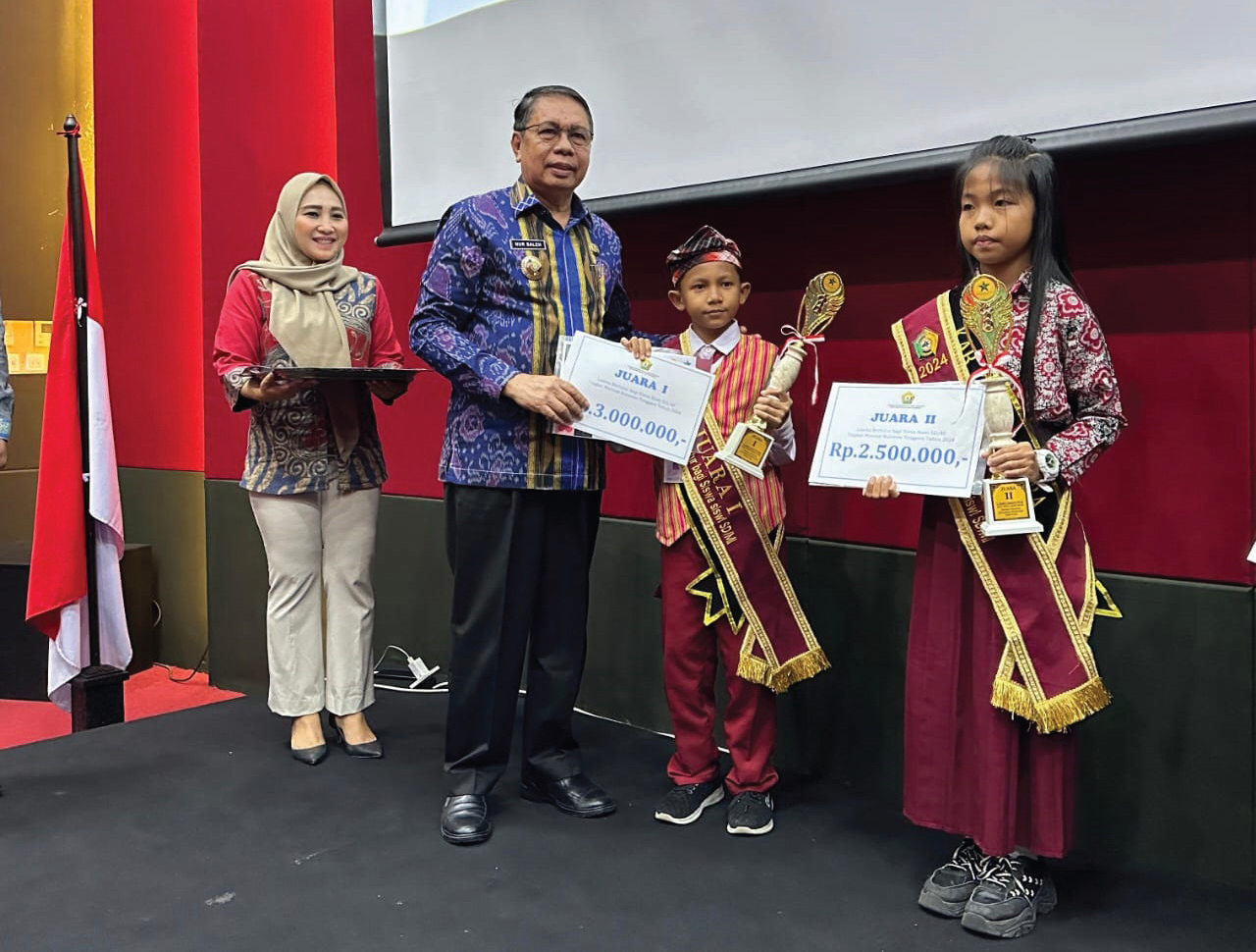 PANGGUNG PARA JUARA : Kepala Dinas Perpustakaan dan Kearsipan Sultra Sultra, Nur Saleh menyerahkan penghargaan kepada pemenang lomba bertutur tingkat SD Sederajat di Kendari, kemarin. (agus setiawan)