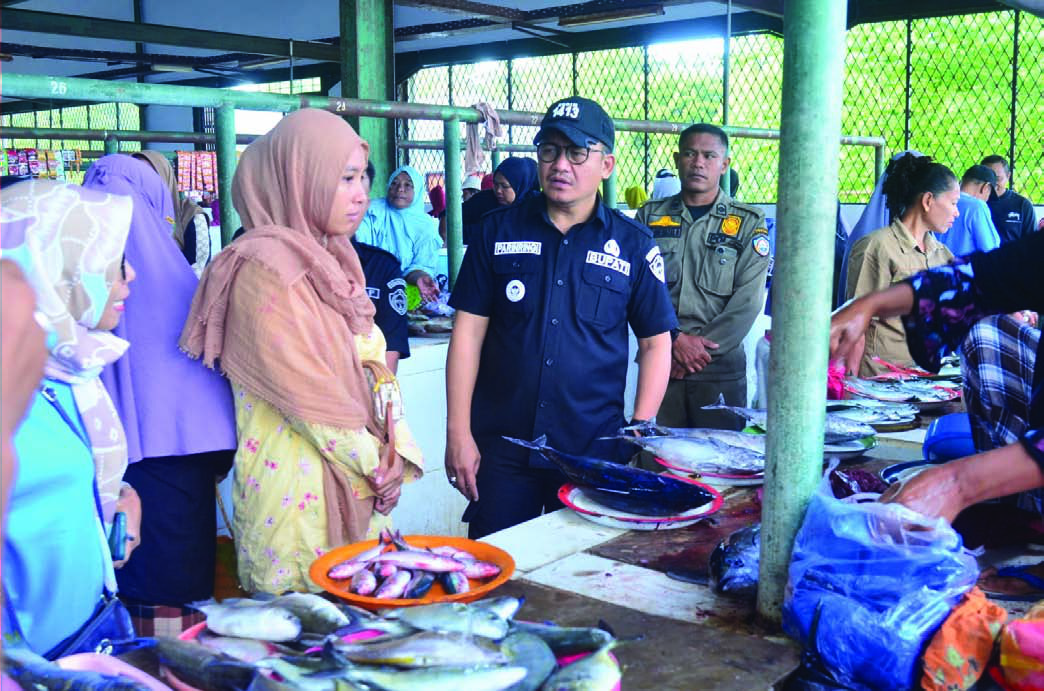 PANTAU PASAR: Pj Bupati Busel, Parinringi (pakai topi) sedang berdiskusi dengan pedagang di Pasar Tradisional Bandar Batauga, Minggu (11/8/2024). Dia ingin memastikan kondisi harga sembako tidak naik. Sekaligus menjaga inflasi tetap stabil dan terkendali. (Elyn/Kendari Pos)