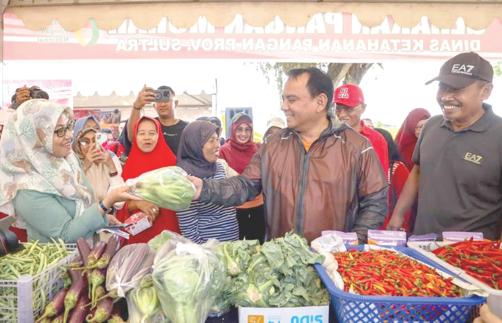 Pj Gubernur Sultra, Andap Budhi Revianto (2 dari kanan) berbagi bahan pangan kepada masyarakat saat meninjau Gerakan Pangan Murah.