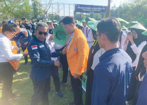 Rektor UHO, Prof. Dr. Ir Muhamad Zamrun Firihu, S.Si., M.Si., M.SC menyematkan almamater UHO kepada salah satu perwakilan sebagai tanda resminya menjadi Maba UHO. (IST)