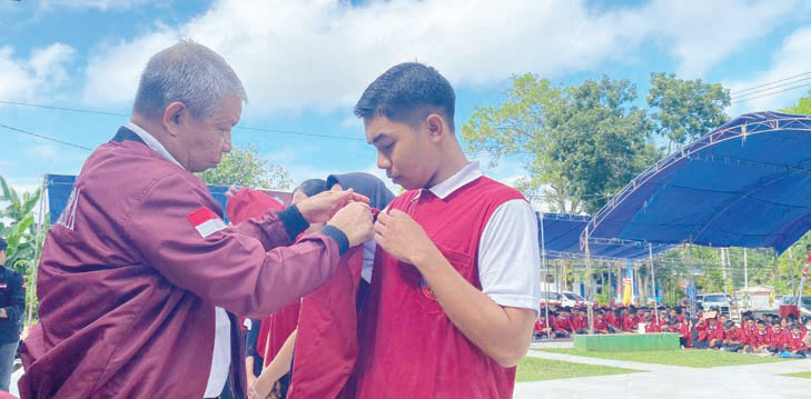 Rektor Unsultra, Prof Dr Andi Bahrun menyematkan almamater kepada salah satu perwakilan Maba 2024. (HUMAS UNSULTRA)