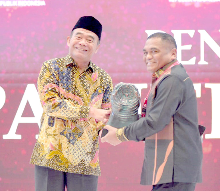 Pj Bupati Mubar, La Ode Butolo (kanan) menerima penghargaan paritrana award dari BPJS Ketenagakerjaan yang diserahkan oleh Mentri Koordinator Pembangunan Manusia dan Kebudayaan Republik Indonesia, Muhadjir Effendy (kiri). (KOMINFO MUBAR FOR KENDARI POS)