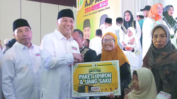 Bakal calon Wali Kota Kendari, Aksan Jaya Putra (2 dari kiri) didampingi bakal calon Wakil Wali Kota Kendari, Andi Sulolipu (kiri) menyerahkan hadiah umrah gratis kepada warga yang beruntung mendapat doorprize dalam zikir akbar, Selasa (17/9/2024). (AGUS SETIAWAN / KENDARI POS)