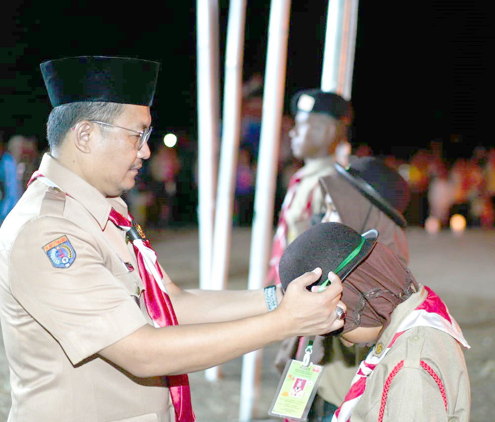 Pj Bupati Busel Parinringi mengenakan tanda pengenal kepada peserta Kemah Budaya IV di Bumi Perkemahan La Ode Waridi, Kelurahan Masiri Batauga.