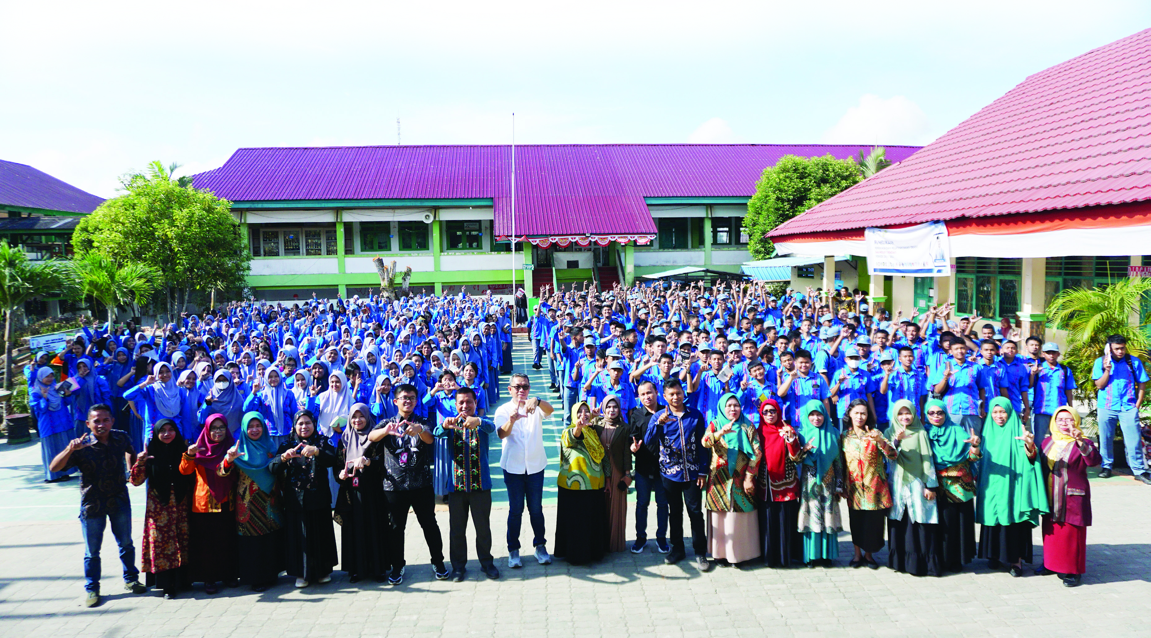 Direktur Kendari Pos, Irwan Zainuddin (9 dari kiri), Supervisor Mobile Consumer Operations Territory (MCOT) Telkomsel Kendari, Fajar Syahrurramdhan (7 dari kiri) dan Kepala SMAN 1 Kendari, Ruslan (8 dari kiri) bersama para guru dan ratusan siswa SMAN 1 Kendari dalam kegiatan road to school, Kamis (26/9/2024). (MUH. ABDI ASMAUL/KENDARI POS)