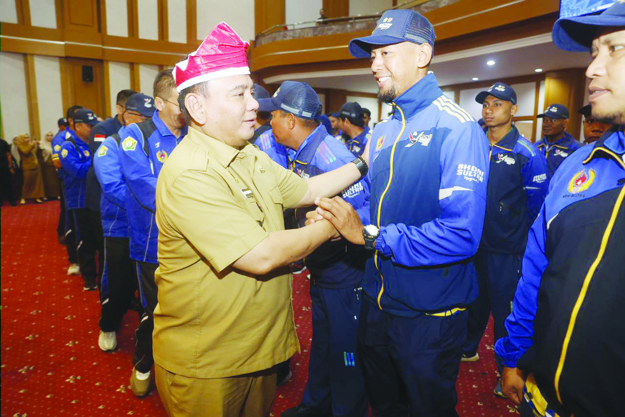 PELEPASAN KONTINGEN PON : Pj Gubernur Sultra Andap Budhi Revianto menyalami atlet pada pelepasan kontingen Sultra yang akan berlaga pada PON XXI di ruang pola kantor Setprov Sultra, Senin (2/9). (RAHMA SAFITRI/KENDARI POS)