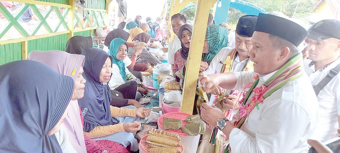 Calon Bupati Mubar La Ode Darwin membeli jualan pedagang pasar sore Desa Lindo sembari berdiskusi. (AKHIRMAN/KENSARI POS)