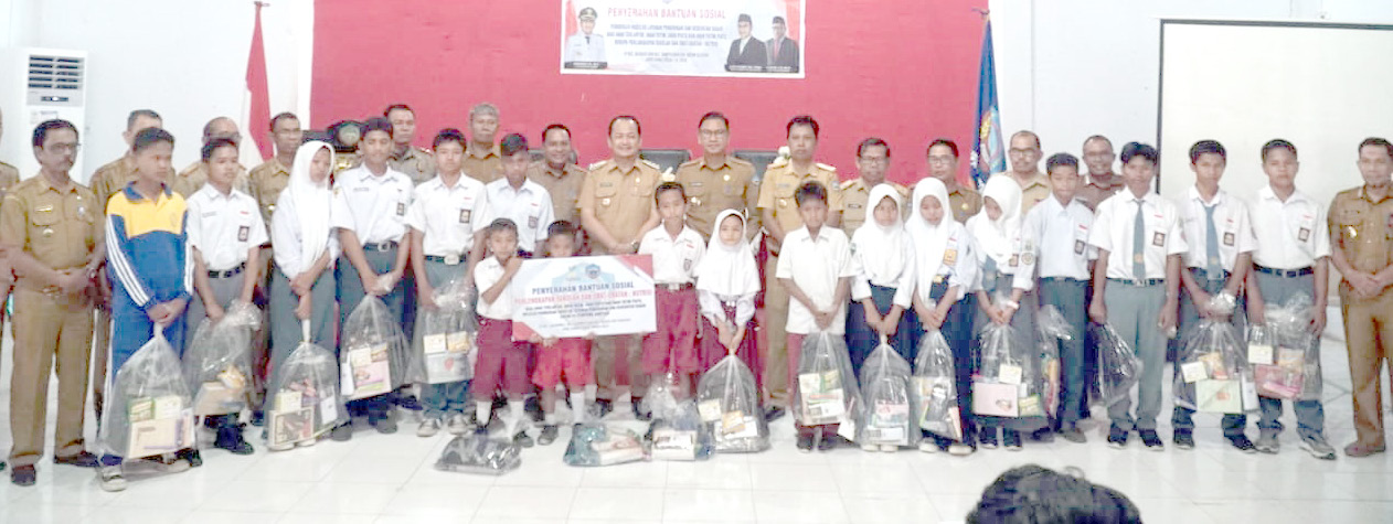 BANTUAN: Pj. Bupati Busel, Parinringi (tengah) foto bersama jajaran, guru, dan siswa usai penyaluran bantuan sosial di Gedung Lamaindo, Batauga, Selasa, 3 September 2024. (ELYN/KENDARI POS)