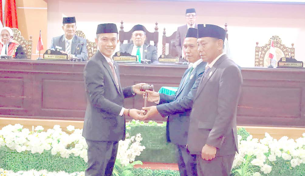 MULAI BEKERJA : Mantan Ketua DPRD Konut, Ikbar (kiri) saat menyerahkan palu sidang pada pimpinan sementara, Herman Sewani didampingi wakilnya, I Made Tarubuana, dalam pelantikan anggota legislatif. (PROKOPIM SETKAB KONAWE UTARA FOR KENDARI POS)