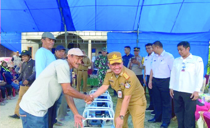 BANTUAN: Sekda Kota Kendari, Ridwansyah Taridala (kanan), menyerahkan bantuan mesin pompa air kepada petani di Kawasan Persawahan Amohalo Baruga, kemarin.