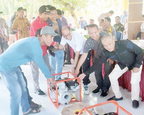 INTERVENSI : Bupati Konsel, H. Surunuddin Dangga (tengah) saat menyerahkan bantuan pompa air untuk kegiatan pertanian kepada masyarakat di Kecamatan Ranomeeto Barat. (I NGURAH PANDI SANTOSA/ KENDARI POS)