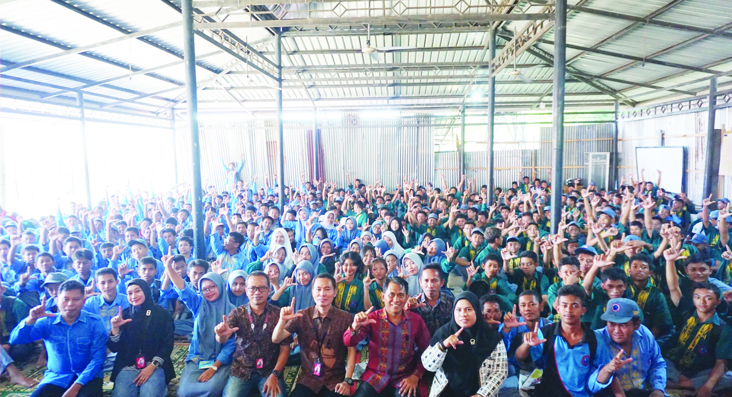 Pemimpin Redaksi Kendari Pos, Inong Saputra (kiri), General Manager Consumer Business Region Sulawesi PT Telkomsel, Kuntum Wahyudi (5 dari kiri), Manager Household Operation Regional Sulawesi, Karlina Rivai (2 dari kiri) dan Kepala SMKN 2 Kendari, Ahmad Mustapa (5 dari kanan) menunjukkan gestur Salam Literasi dalam acara road to school di SMKN 2 Kendari, Kamis (17/10/2024). (MUH.ABDI ASMAUL AMRIN / KENDARI POS)