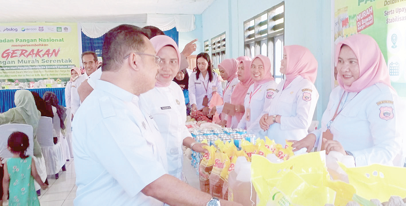 SOLUSI KEBUTUHAN PANGAN : Asisten Bidang Administrasi dan Keuangan Setkab Butur, Zainal Arifin HZ (kiri) ketika membuka gerakan pangan murah yang digelar serentak secara nasional, di Desa Eerinere, Kecamatan Kulisusu Utara. (DISKOMINFO KABUPATEN BUTON UTARA FOR KENDARI POS)