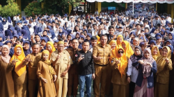 Wakil Direktur Kendari Pos, Awal Nurjadin (tengah, kemeja hitam), Staf Mobile Consumer Operations Territory (MCOT) Telkomsel Kendari, Sandra (6 dari kanan), Kepala SMPN 1 Kendari, Abdul Hamid (9 dari kanan) bersama para guru dan siswa SMPN 1 Kendari menunjukkan gestur Salam Literasi dalam acara road to school, Selasa (22/10/2024).(MUH.ABDI ASMAUL AMRIN / KENDARI POS)