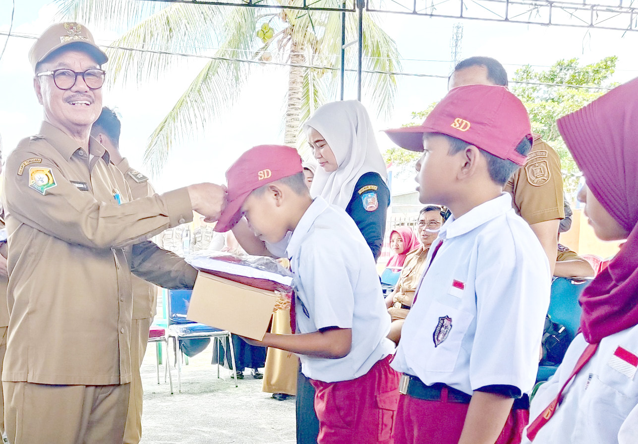 PERHATIAN PEMERINTAH : Bupati Konsel, H. Surunuddin Dangga (kiri) dalam kunjungan ke berbagai kecamatan di otoritanya, sekaligus menyalurkan sejumlah bantuan, termasuk susu dan makanan bergizi, serta seragam bagi murid SD hingga SMP. (DISKOMINFO KABUPATEN KONAWE SELATAN FOR KENDARI POS)