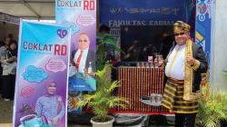 Dekan FF UHO, Prof. Dr. Ruslin, M.Si, memegang produk Kopi RD, salah satu produk unggulan yang dipamerkan di stand Fakultas Farmasi UHO pada KMI Expo XV 2024. (Ewin Endang Sahputri/Kendari Pos)