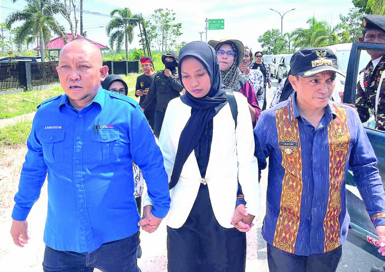 Supriyani (tengah), guru honorer SDN 4 Baito saat tiba di PN Andoolo untuk menjalani sidang perdana. Supriyani dikawal kuasa hukumnya, Samsuddin, SH (kiri) dan Camat Baito, Sudarsono Mangidi (kanan). (I NGURAH PANDI SANTOSA / KENDARI POS)