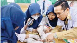 Parudin, S.Pd., M.Pd., guru SMPN 1 Kendari, saat mengajar siswa-siswi. (EWIN ENDANG SAHPUTRI/KENDARI POS)