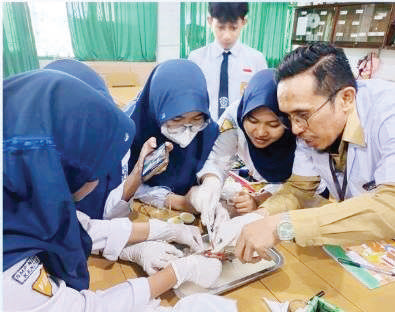 Parudin, S.Pd., M.Pd., guru SMPN 1 Kendari, saat mengajar siswa-siswi. (EWIN ENDANG SAHPUTRI/KENDARI POS)