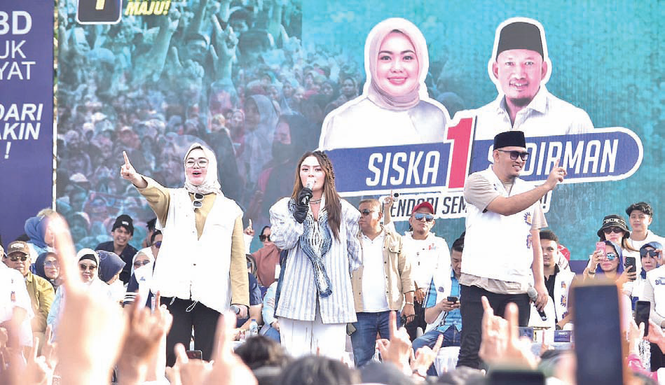 Calon Wali Kota Kendari, dr.Siska Karina Imran (kiri), calon Wakil Wali Kota Kendari, Sudirman (kanan) bersama pedangdut Siti Badriah (tengah) dalam kampanye terbatas di Lapangan Torada, Kecamatan Puuwatu, Kota Kendari, Selasa (19/11/2024).