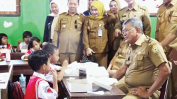 Pj Wali Kota Kendari, Muhammad Yusup berbincang dengan murid SD Negeri 1 Kendari. Ia memastikan setiap anak mendapatkan makan siang gratis.