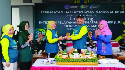 Pj Sekda Kota Kendari, dr.Sukirman menyerahkan potongan tumpeng kepada Ketua Tim Penggerak PKK Kota Kendari, Ira Willis Kesumadoty dalam perayaan HKN 2024.