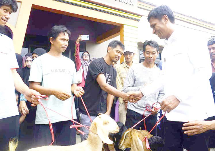 KERAWANAN PANGAN: Pj Bupati Kolut, Yusmin (kanan) ketika turut menyerahkan bantuan dari Dinas Ketahanan Pangan Provinsi Sultra kepada warganya di Desa Raoda, Kecamatan Lambai. (DINAS KOMINFO KABUPATEN KOLAKA UTARA FOR KENDARI POS)