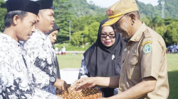 HARI GURU NASIONAL : Sekda Kolut Taupiq menyerahkan penghargaan kepada guru pada peringatan hari guruj nasional di lapangan Aspirasi Lasusua, Senin (25/11)