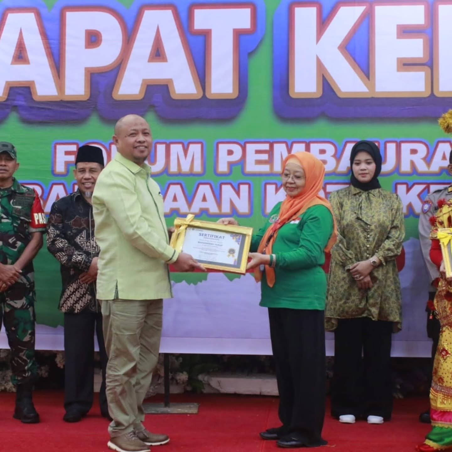 AGUS SETIAWAN / KENDARI POS Pj Sekda Kota Kendari, dr. Sukirman (kiri) menyerahkan sertifikat penghargana kepada Ketua Forum Pembauran Kebangsaan (FPK) Kota Kendari, Sri Yastin (kanan) dalam rapat kerja FPK Kota Kendari, Senin (23/12/2024).