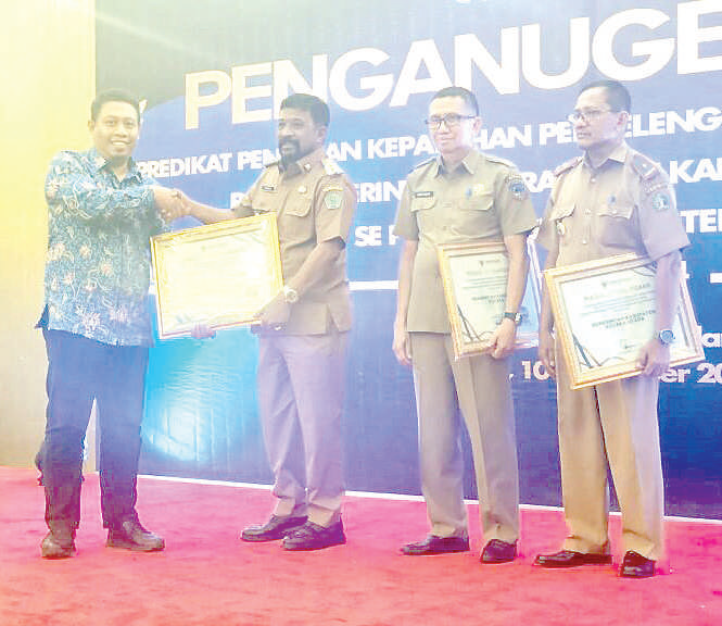 DINAS KOMINFO KABUPATEN KONAWE FOR KENDARI POS TRANSPARAN : Pj Bupati Konawe, Stanley (kedua dari kiri) saat menerima penghargaan kategori A penyelenggaraan pelayanan publik oleh pihak Ombudsman RI.