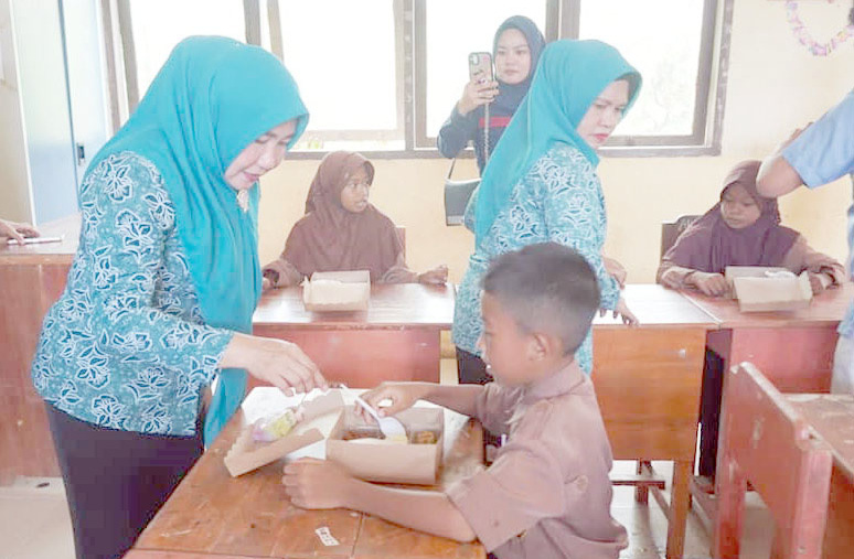 PEMENUHAN NUTRISI : Pj Ketua TP-PKK Kolut, Nurhayati Yusmin (kiri) saat turun melihat langsung realisasi kegiatan program makanan bergizi gratis bagi anak sekolah di Kecamatan Batu Putih.